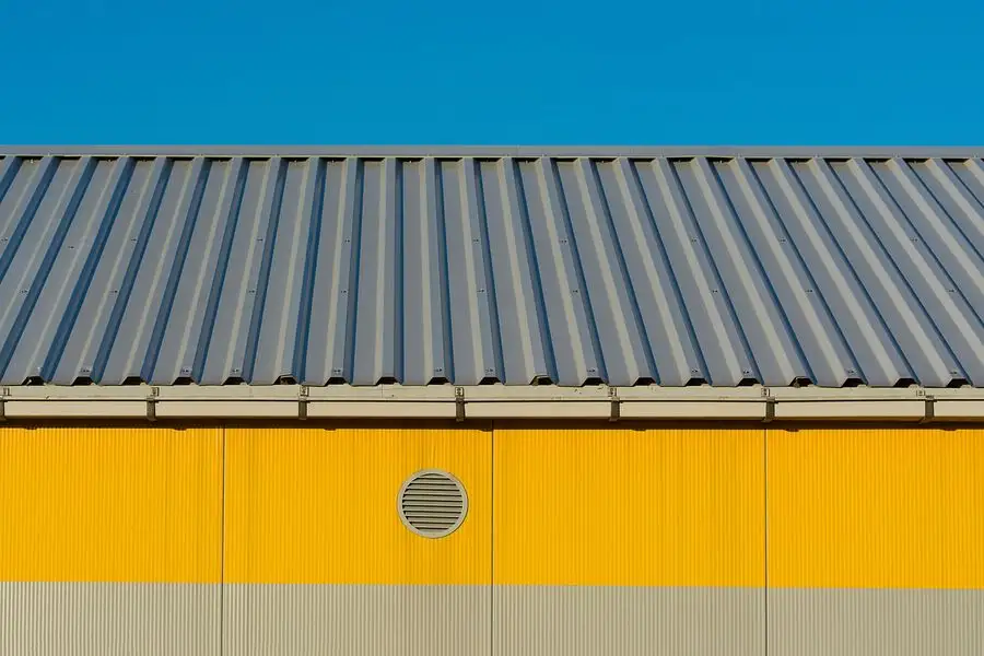 Yellow painted building facade under a metal roof