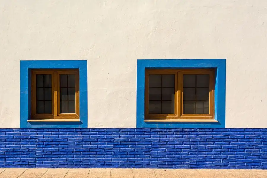 White rendered wall with blue-framed windows